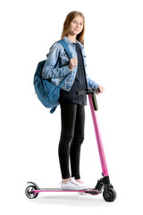 Portrait of cute teenage girl with kick scooter on white background