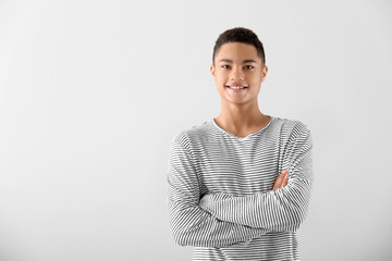 Portrait of African-American teenage boy on grey background