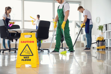 Sign board on floor in office during cleaning