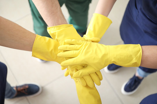 Team Of Janitors Putting Hands Together