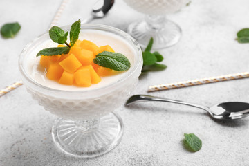 Bowl of delicious panna cotta on grey table