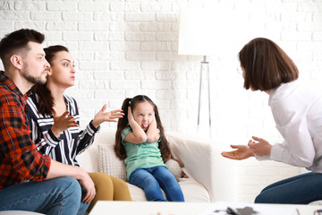 Female psychologist working with naughty little girl in office