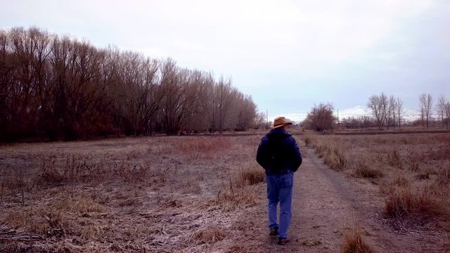 Mature man walks along a rural dirt path