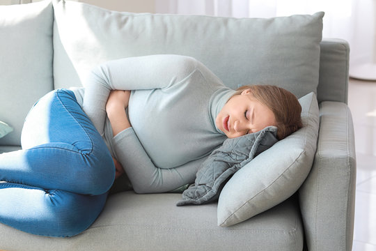 Young woman suffering from stomachache at home