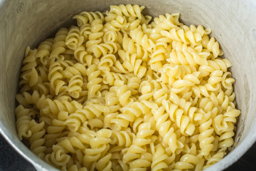 Cooked pasta in an enamel saucepan.