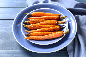 Plate with cooked carrot on table