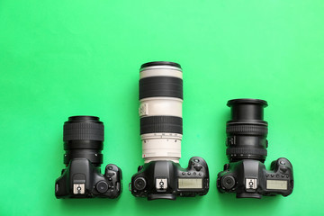 Different professional photo cameras on color background