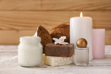 Jar with coconut oil, soap and candles on table