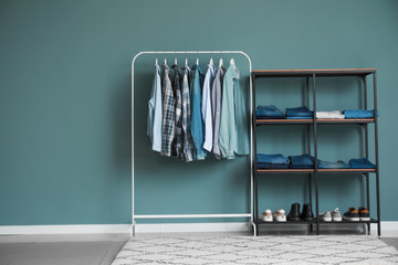 Rack with stylish clothes and shoes in dressing room
