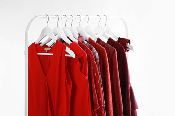 Rack with stylish clothes on white background