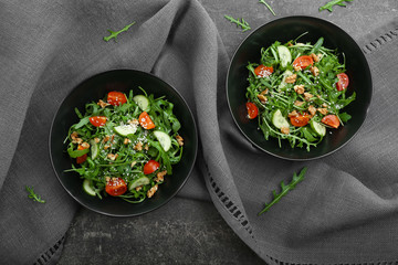 Plates with tasty arugula salad on table