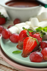Fresh fruits with melted chocolate on plate