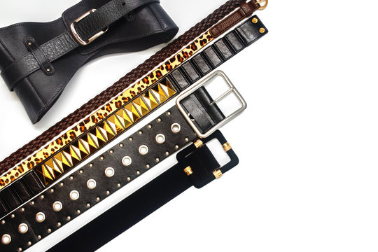 Collection of women's trendy leather belts on white background. Women's fashion accessories. Different types of waistbands and leather corset. Flat lay, copy space, top view.