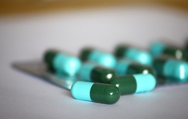 green-blue antibiotic capsule pills in blister pack