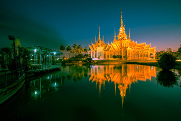 Fototapeta premium Wallpaper Wat Lan Boon Mahawihan Somdet Phra Buddhacharn(Wat Non Kum)is the beauty of the church that reflects the surface of the water, popular tourists come to make merit and take a public photo 