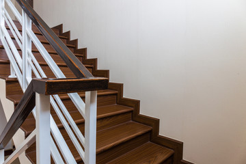 Staircase custom built home interior with wood staircase and white walls. Copy space background
