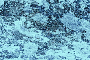 Vintage blue background. Rough painted wall of sapphire color. Imperfect plane of blue colored. Uneven old decorative toned backdrop of cyan tint. Texture of sapphirine hue. Ornamental stony surface.