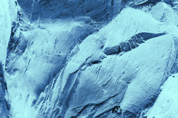Vintage blue background. Rough painted wall of sapphire color. Imperfect plane of blue colored. Uneven old decorative toned backdrop of cyan tint. Texture of sapphirine hue. Ornamental stony surface.