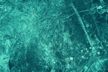 Vintage azure background. Rough painted wall of turquoise color. Imperfect plane of cyan colored. Uneven old decorative toned backdrop of aqzure tint. Texture of teal hue. Ornamental stony surface.