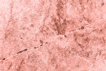 Vintage pink background. Rough painted wall of living coral color. Imperfect plane of beige colored. Uneven old decorative toned backdrop of beige tint. Texture of pink hue. Ornamental stony surface.