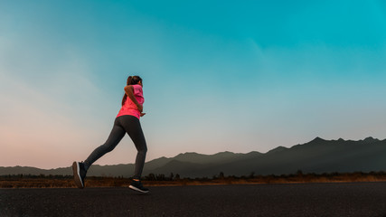 Woman enjoys running outside with beautiful summer evening in the countryside.