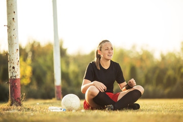 Young female soccer player resting after her training