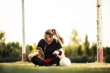 Young female soccer player resting after her training