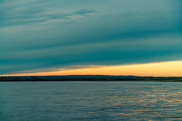 Naklejka premium summer landscape on the banks of the green river at sunset, Russia