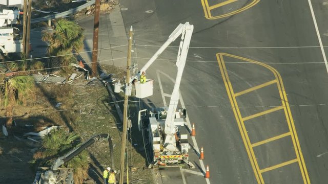 Aerial view utility workmen trucks repairing electricity lines 