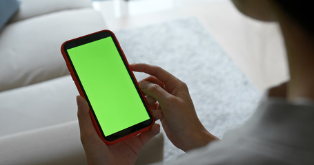 Woman hold a mobile phone with green screen