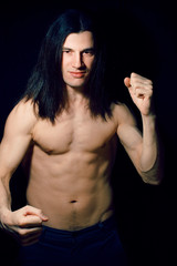 handsome young man with long hair naked torso on black background smiling, lifestyle people concept