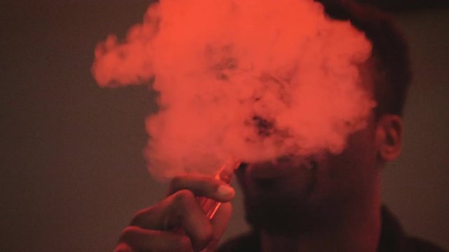 African American man blowing exhaling smoke