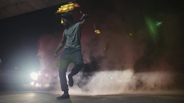 African American male dancing in smoke and headlights