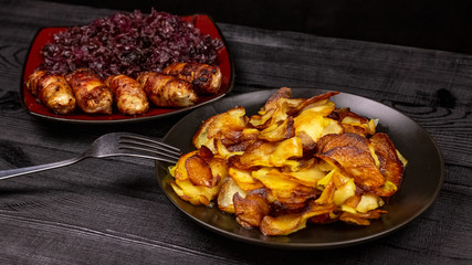 Fried homemade grilled sausages or chevapchichi with stewed sauerkraut on a wooden rustic background