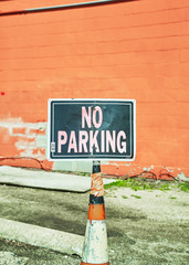 No Parking sign in a parking lot in the middle of the day.