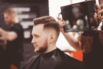 Barbershop banner. Man in barber chair, hairdresser styling his hair.