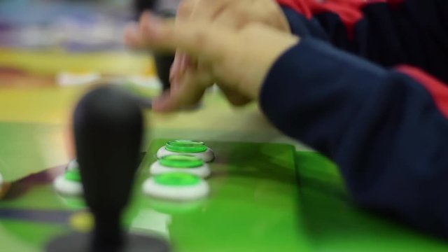 Closeup, unidentified kid playing vintage classic retro arcade console game