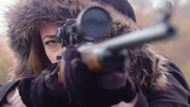 Close up of a woman looking through the scope of a rifle guarding an outpost, 23.98 fps.