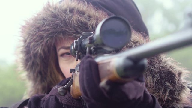Close up of a woman looking through the telescopic sight of a weapon, 23.98 fps.
