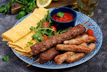 Turkish and Arabic Traditional Ramadan mix kebab plate. Kebab adana, lamb and beef on lavash bread with tomato sauce.