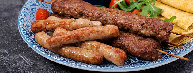 Turkish and Arabic Traditional Ramadan mix kebab plate. Kebab adana, lamb and beef on lavash bread with tomato sauce. Banner
