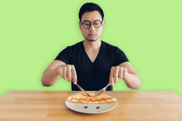 Serious face of man is eating homemade breakfast set of omelet.