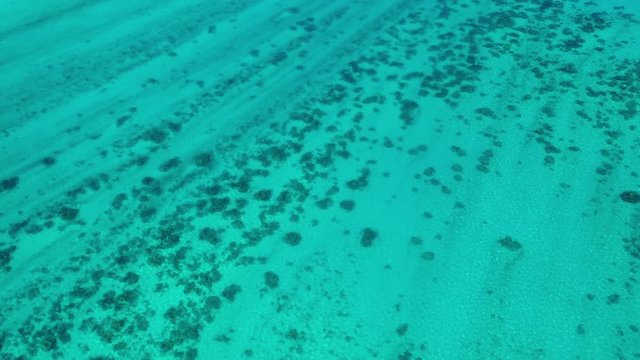French Polynesia Tahiti aerial drone view of motu with perfect beach by island Huahine, coral reef lagoon and Pacific Ocean. Tropical travel paradise.