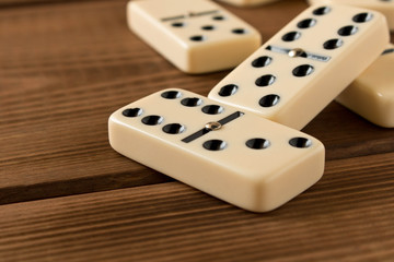Playing dominoes on a wooden table. Domino effect.