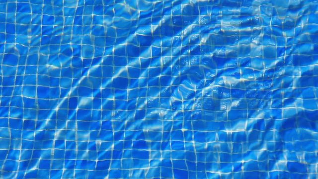 water ripples in swimming pool, blue tile background