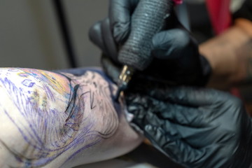 Tattoo master makes a client a colorful tattoo