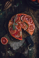 citrus upside down cake with blood oranges, lemons and limes on wooden board among fresh citrus...