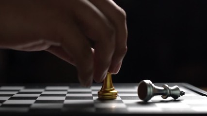 Close up man moving golden king chess defeat enemy on chessboard winner and victory concept,strategy planning business Slowmotion