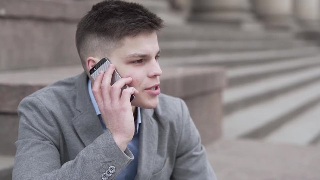 Business man talking on over the phone. A good looking young man.