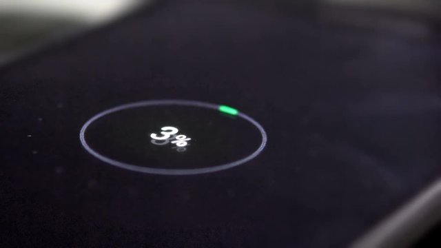 Low battery. Mobile smart phones charging on wooden desk. Cinematic dof